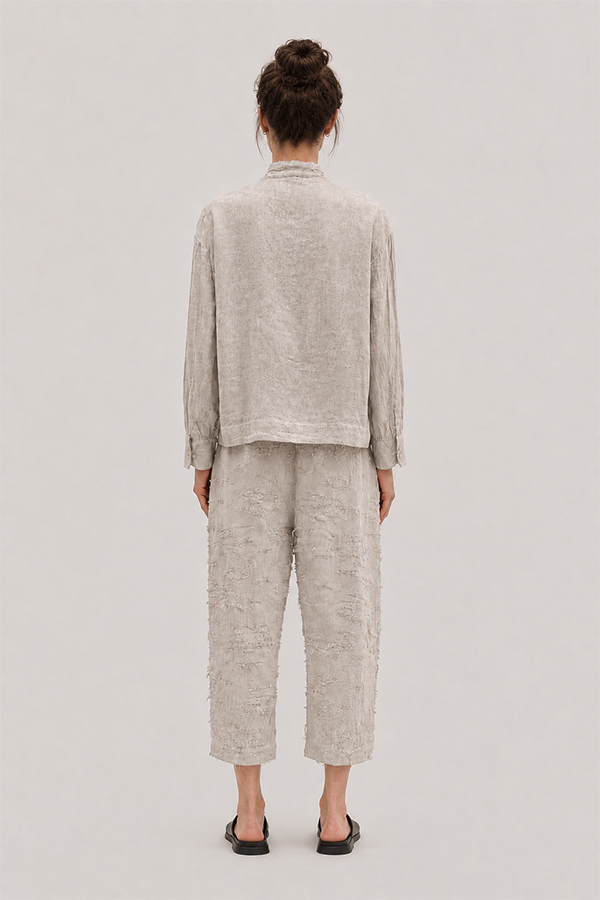 La Vaca Loca Salvd loose-fit asymmetrical shirt in cold white distressed cotton voile fabric with a stand-up collar.