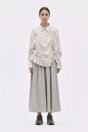 The La Vaca Loca Somatico Shirt Cold White CW is a long-sleeved shirt with a collar and textured, irregular gathers on the front, made of soft voile fabric.