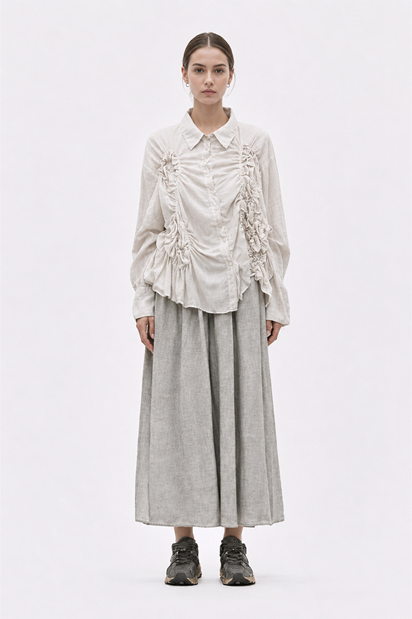 The La Vaca Loca Somatico Shirt Cold White CW is a long-sleeved shirt with a collar and textured, irregular gathers on the front, made of soft voile fabric.