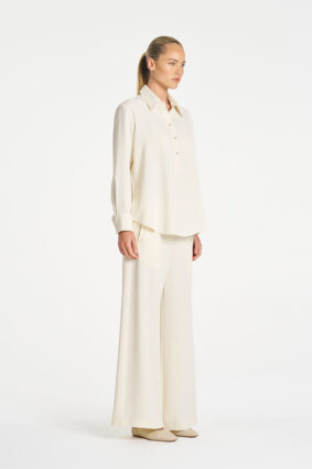 Model wearing Mela Purdie Suit Pant in Vanilla and Black fine vertical stripes.