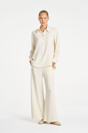 Model wearing Mela Purdie Suit Pant in Vanilla and Black fine vertical stripes.