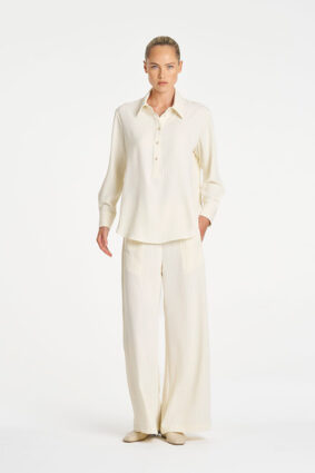 Model wearing Mela Purdie Suit Pant in Vanilla and Black fine vertical stripes.