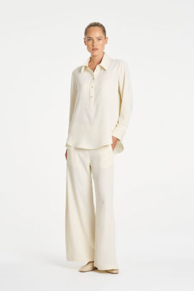 Model wearing Mela Purdie Suit Pant in Vanilla and Black fine vertical stripes.
