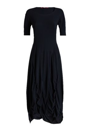 Model wearing the High Tech On Top Dress, featuring a fitted bodice, gathered seams, a wide silhouette from the waist down, and an asymmetric hem.