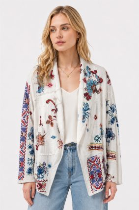 Model wearing the Johnny Was Noemi Jacket Armeria White, an ivory cotton statement jacket featuring rich floral embroidery, paisley motifs, and intricate geometric contrast detailing in cobalt, crimson, and turquoise.