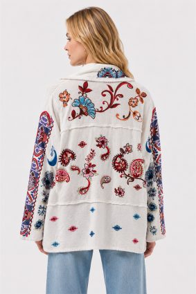 Model wearing the Johnny Was Noemi Jacket Armeria White, an ivory cotton statement jacket featuring rich floral embroidery, paisley motifs, and intricate geometric contrast detailing in cobalt, crimson, and turquoise.