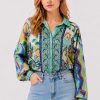 Model wearing the Johnny Was The Audrey Button Up Shirt Rosea, a fluid silk blouse featuring an intricate medley of paisley, floral, and ornamental motifs in aqua, turquoise, cobalt, lime, and golden yellow.