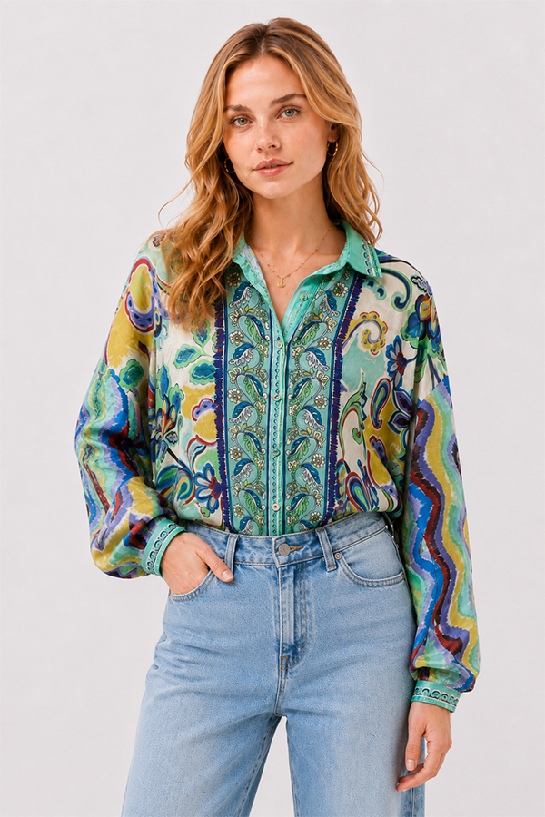 Model wearing the Johnny Was The Audrey Button Up Shirt Rosea, a fluid silk blouse featuring an intricate medley of paisley, floral, and ornamental motifs in aqua, turquoise, cobalt, lime, and golden yellow.