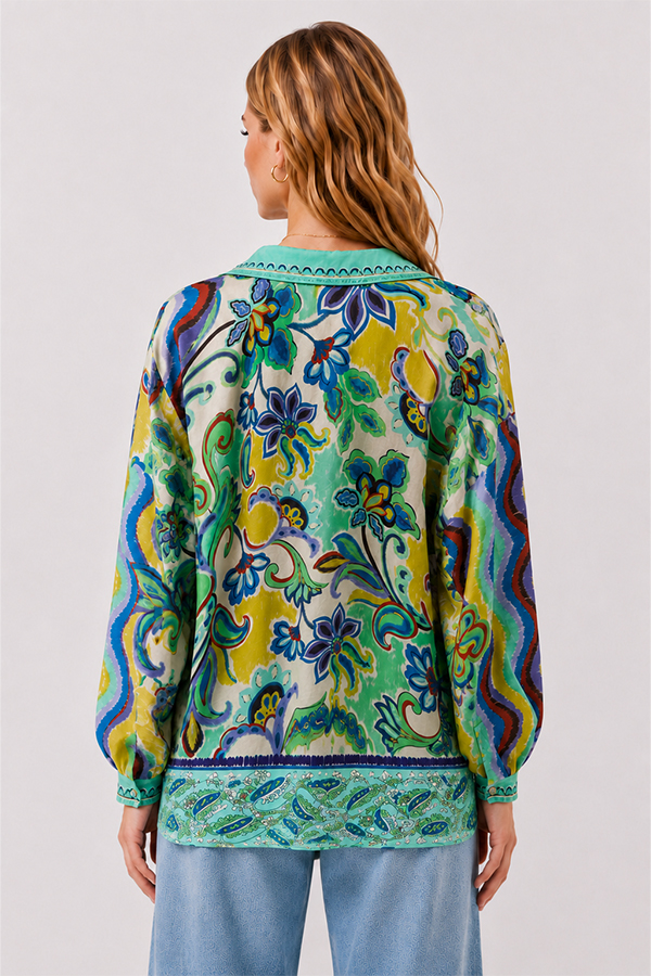 Model wearing the Johnny Was The Audrey Button Up Shirt Rosea, a fluid silk blouse featuring an intricate medley of paisley, floral, and ornamental motifs in aqua, turquoise, cobalt, lime, and golden yellow.