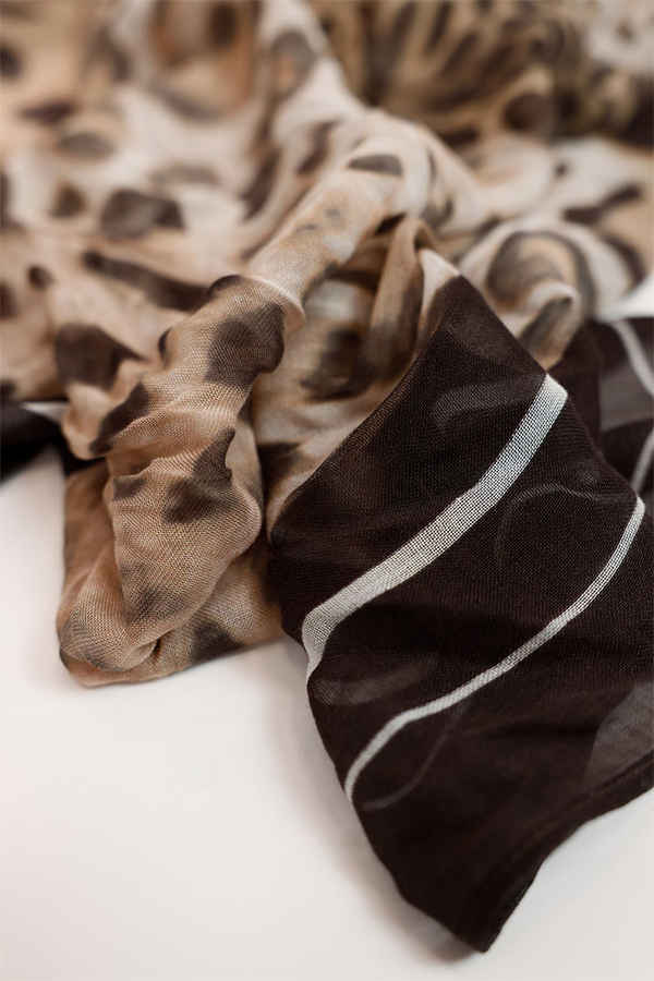 Monari sand-colored leopard print leglet scarf featuring a bold feline motif worn by a model.
