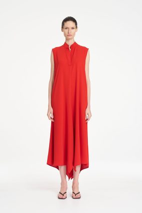 Mela Purdie Tab Soire Dress in vibrant papaya featuring a fluid silhouette, stand collar, open neckline, and asymmetric handkerchief hem