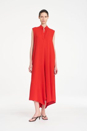 Mela Purdie Tab Soire Dress in vibrant papaya featuring a fluid silhouette, stand collar, open neckline, and asymmetric handkerchief hem