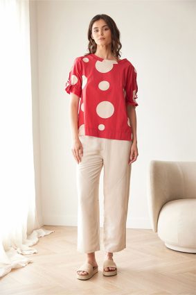 Peruzzi Polka Dot Cotton Top Red featuring a bold red and cream polka dot print with a relaxed silhouette and feminine tie detailing at the cuffs.