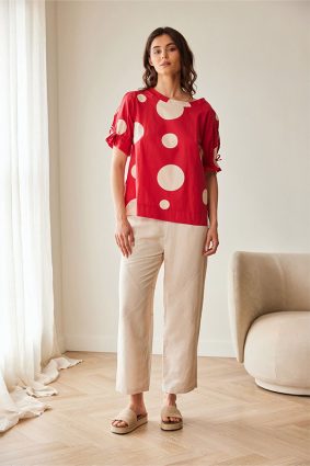Peruzzi Polka Dot Cotton Top Red featuring a bold red and cream polka dot print with a relaxed silhouette and feminine tie detailing at the cuffs.