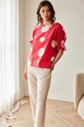 Peruzzi Polka Dot Cotton Top Red featuring a bold red and cream polka dot print with a relaxed silhouette and feminine tie detailing at the cuffs.