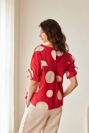 Peruzzi Polka Dot Cotton Top Red featuring a bold red and cream polka dot print with a relaxed silhouette and feminine tie detailing at the cuffs.