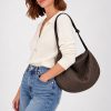 The In.Zu Bean Bag Brown Dots BND features a relaxed crescent shape, textured dot design and adjustable shoulder strap.