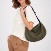The In.Zu Bean Bag Green Dots features a relaxed crescent shape, textured dot design and adjustable shoulder strap.