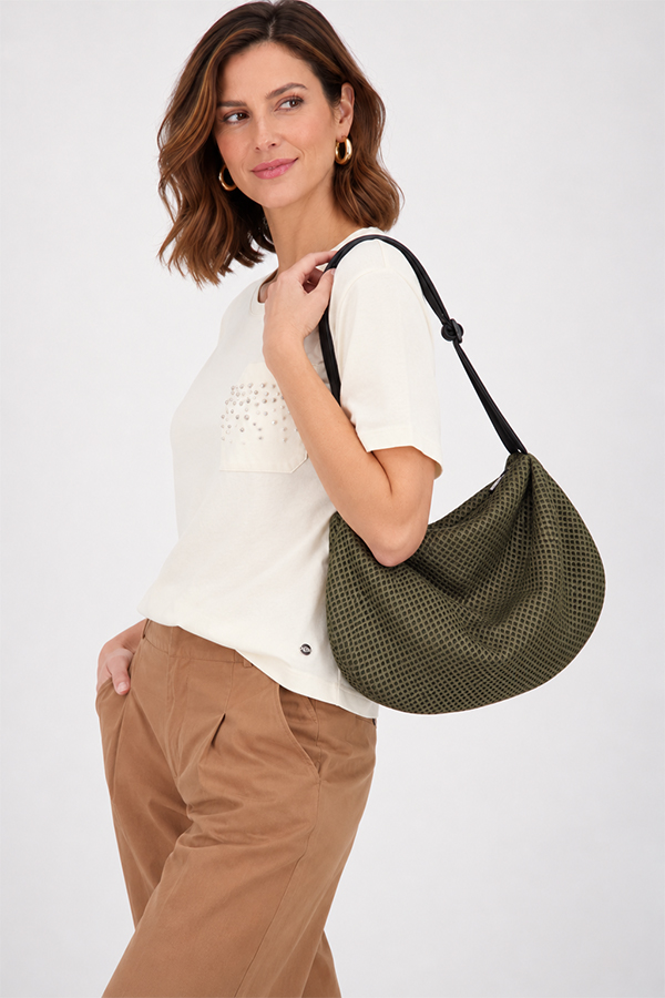 The In.Zu Bean Bag Green Dots features a relaxed crescent shape, textured dot design and adjustable shoulder strap.