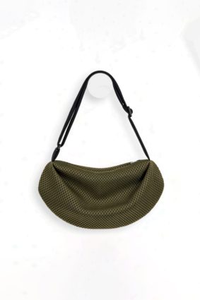 The In.Zu Bean Bag Green Dots features a relaxed crescent shape, textured dot design and adjustable shoulder strap.