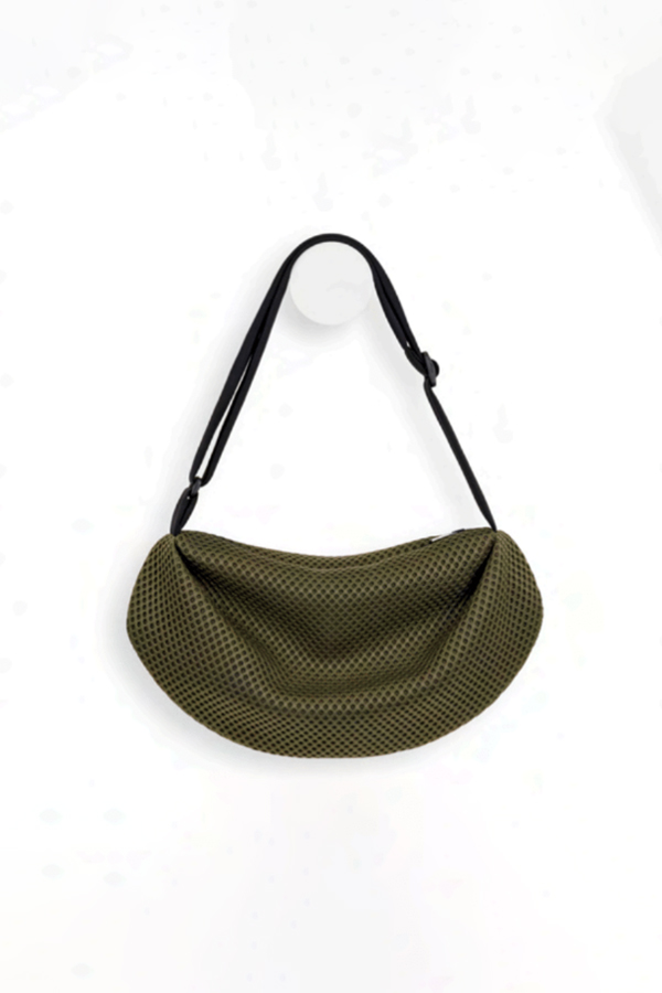 The In.Zu Bean Bag Green Dots features a relaxed crescent shape, textured dot design and adjustable shoulder strap.