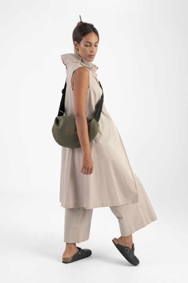 The In.Zu Bean Bag Green Dots features a relaxed crescent shape, textured dot design and adjustable shoulder strap.