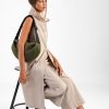 The In.Zu Bean Bag Green Dots features a relaxed crescent shape, textured dot design and adjustable shoulder strap.