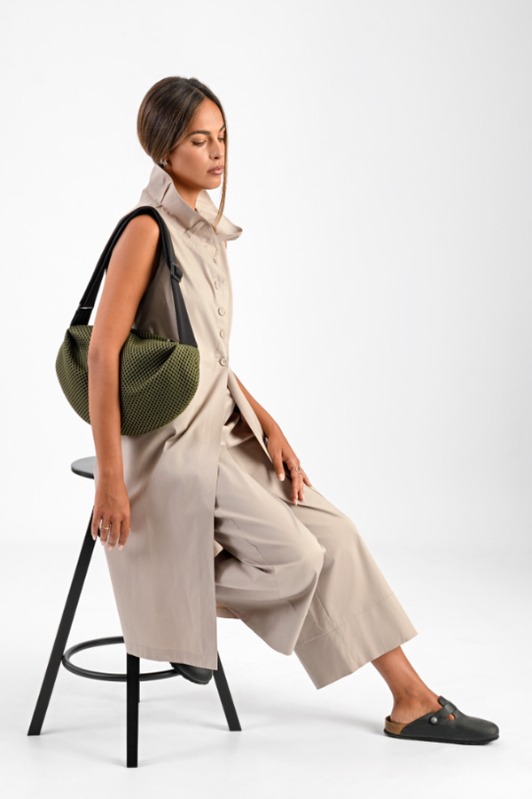 The In.Zu Bean Bag Green Dots features a relaxed crescent shape, textured dot design and adjustable shoulder strap.