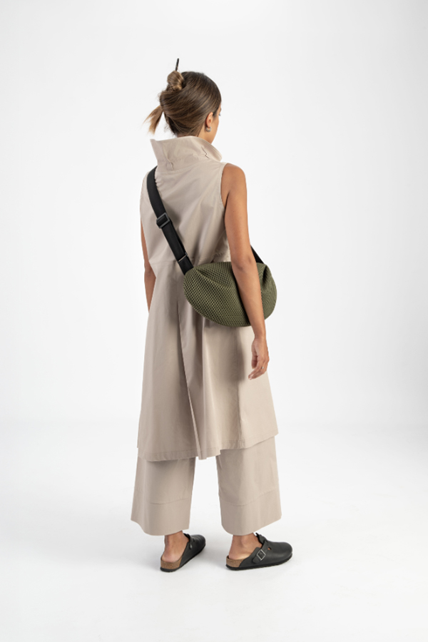 The In.Zu Bean Bag Green Dots features a relaxed crescent shape, textured dot design and adjustable shoulder strap.